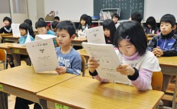 終業式のあと、通信票を受け取る１年生＝亘理町立長瀞小学校